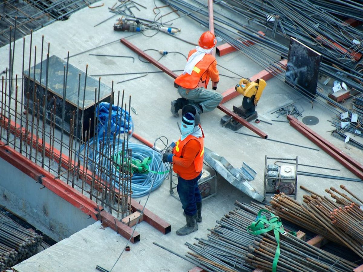 Construction workers on a concrete deck laying reinforcing steel